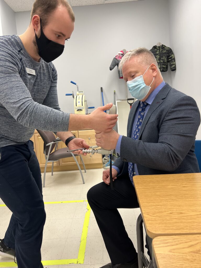 Healthcare professional helping a person with a hand strength exercise