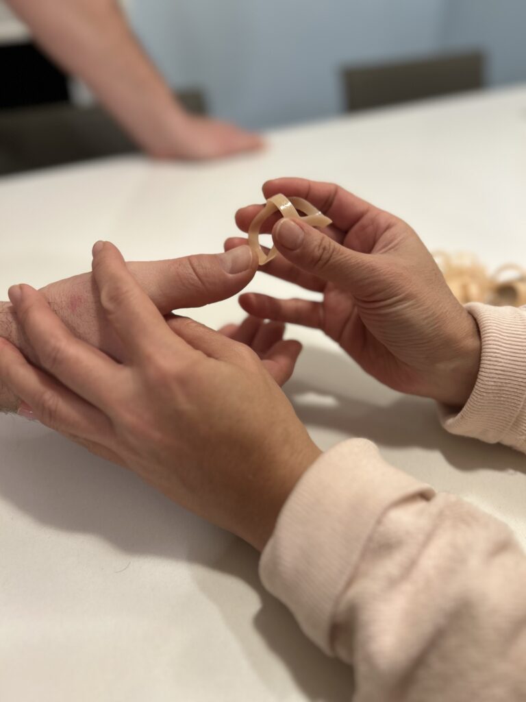 Therapist helps place a splint on a patient’s thumb