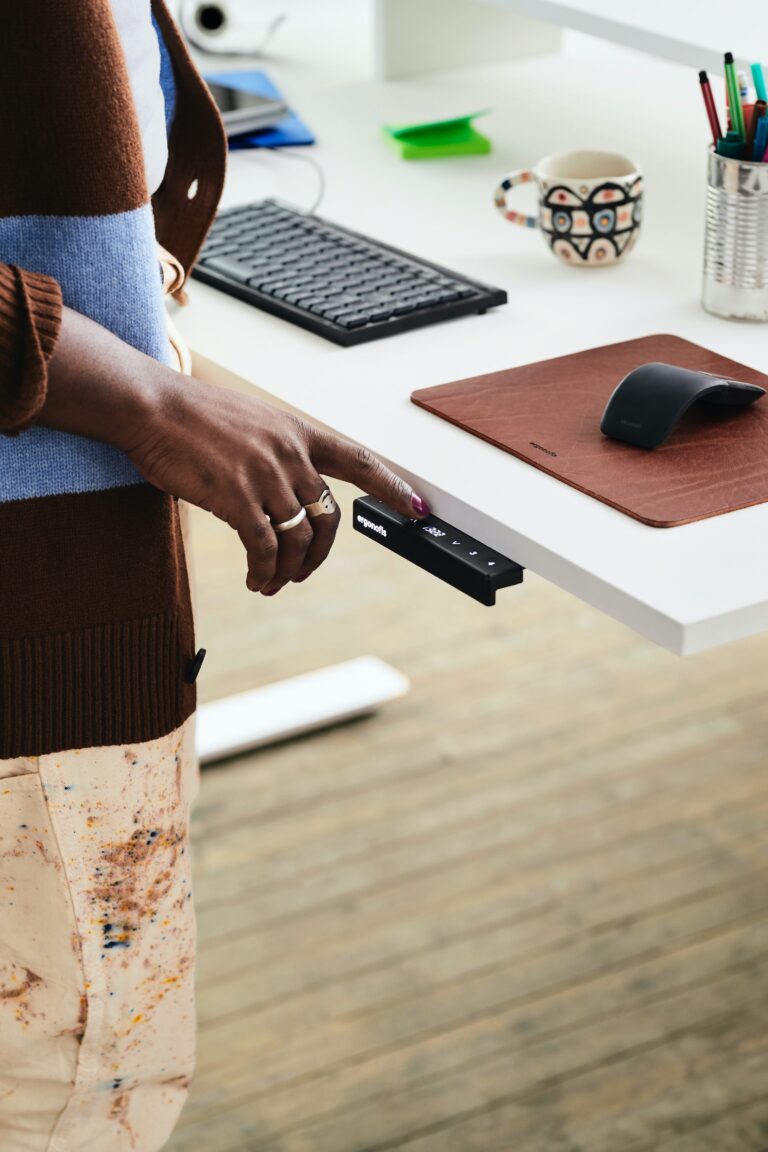 Woman pressing the controls on an adjustable desk